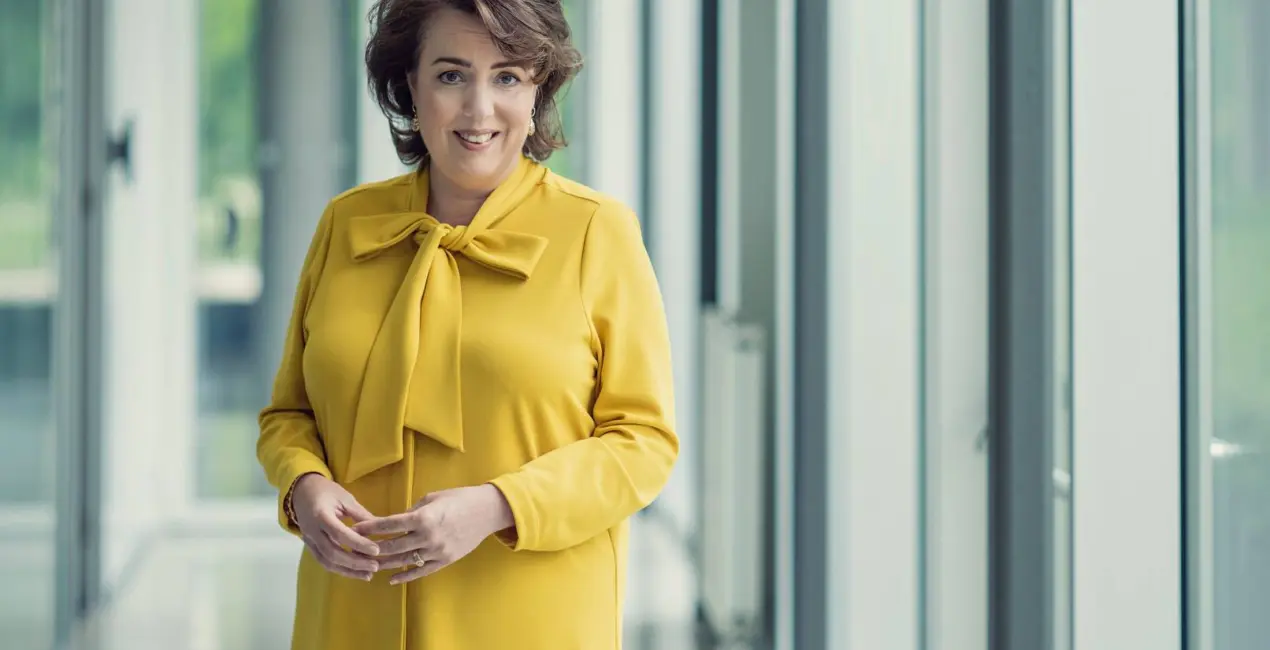 Een foto van Manon van Beek van TenneT staand in een gele jas.
