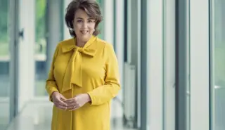 Een foto van Manon van Beek van TenneT staand in een gele jas.