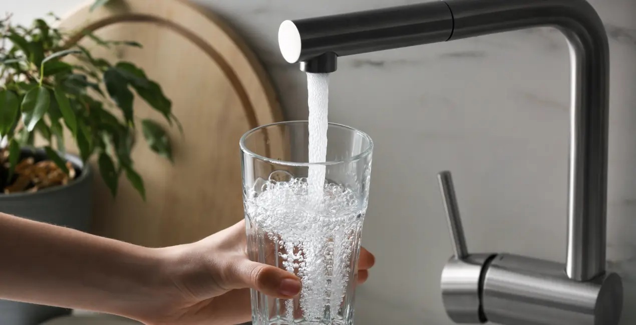 Glas wordt in keuken gevuld met kraanwater